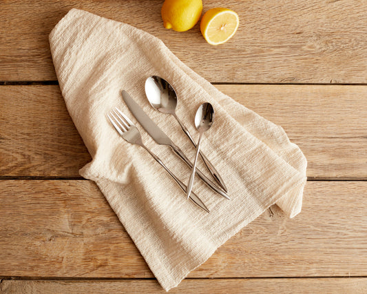 Mayfair Silver stainless steel cutlery set of 4 arranged on a linen napkin