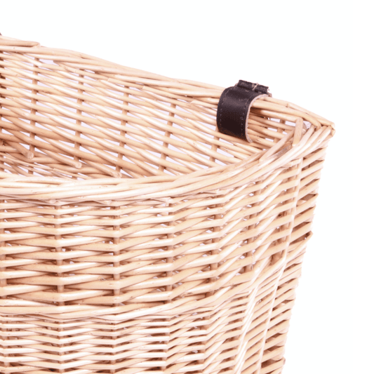 Close-up of a natural willow weave basket with a black leather strap detail