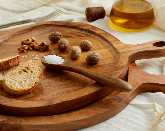 Close view of Richmond Serving Board Set in natural wood with spoons on linen table with salt, nuts and bread