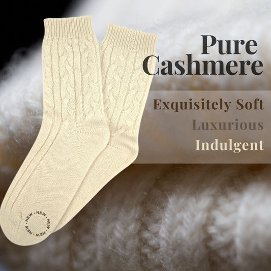 Soft cream cable knit cashmere sleep socks in heritage style, shown folded on a cozy neutral background.