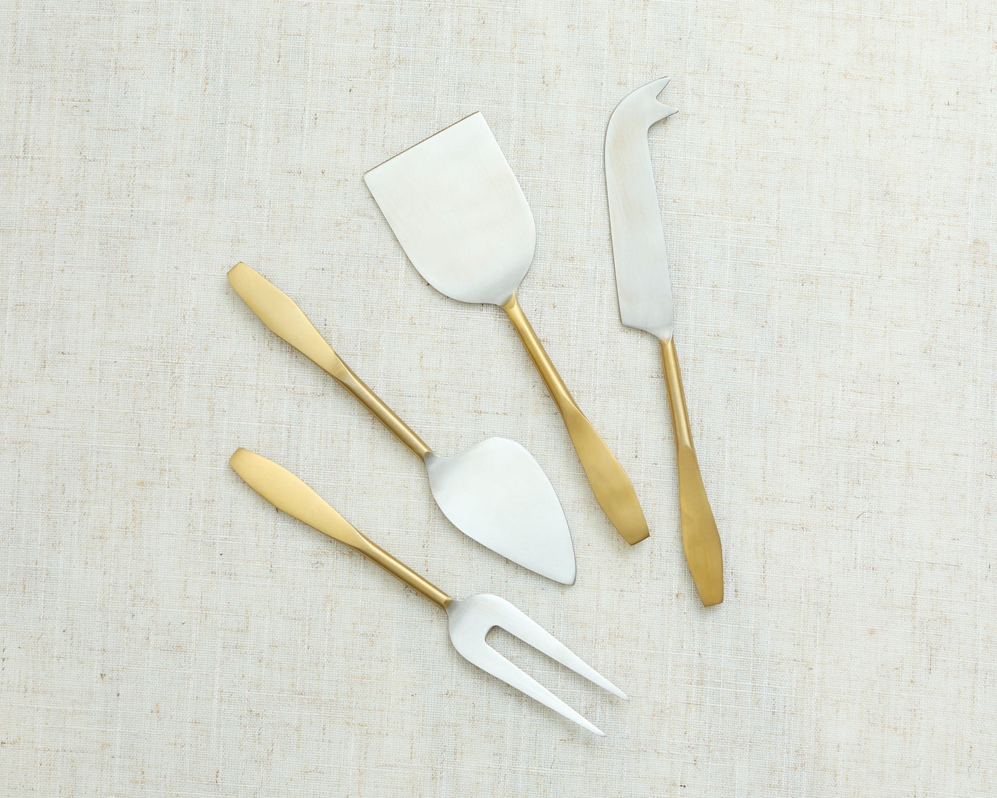 Edith cheese cutlery set 4 piece stainless steel serving set laid out on white tablecloth
