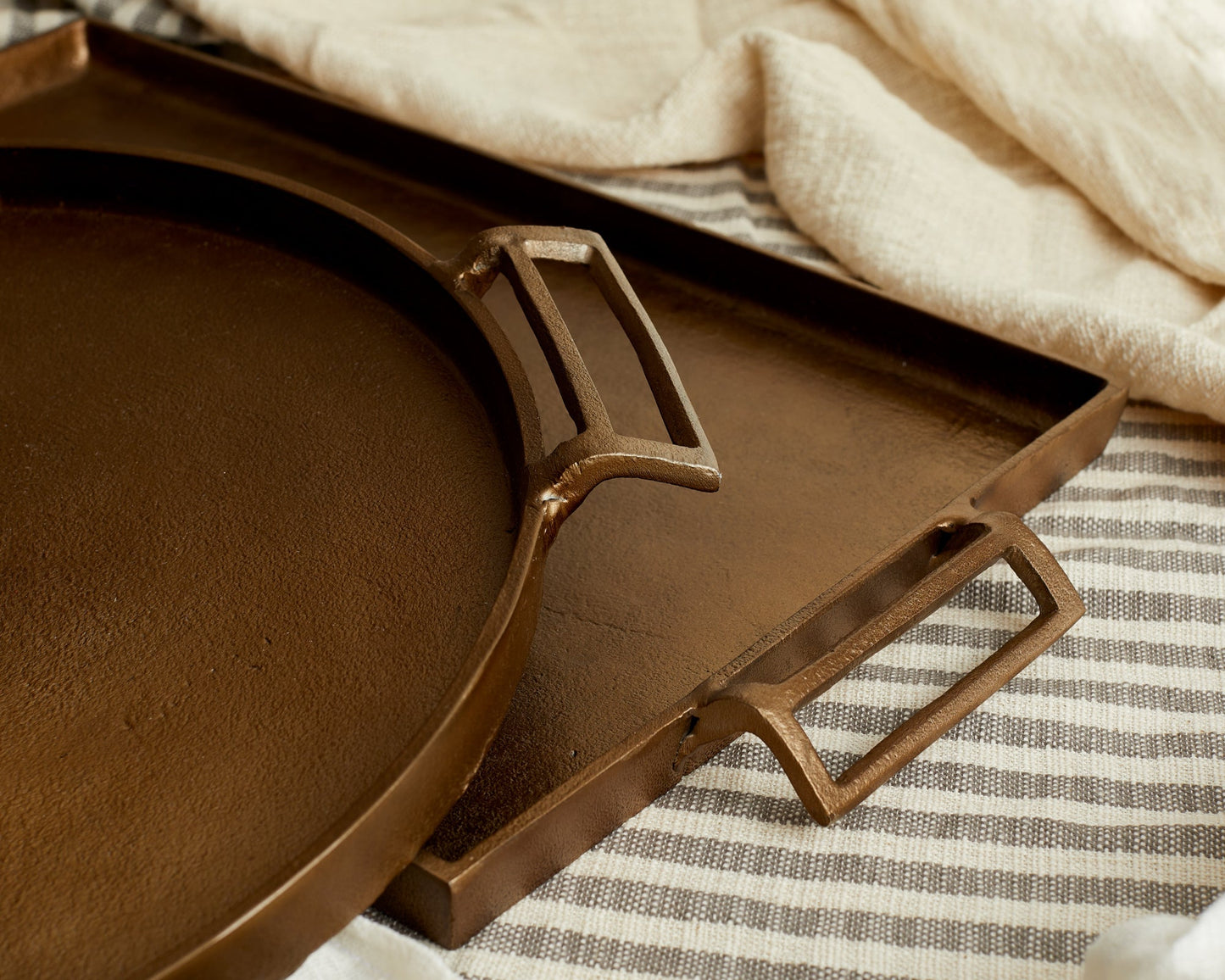 Brontë Bronze rustic serving tray UK close up styled with linen underneath round tray

