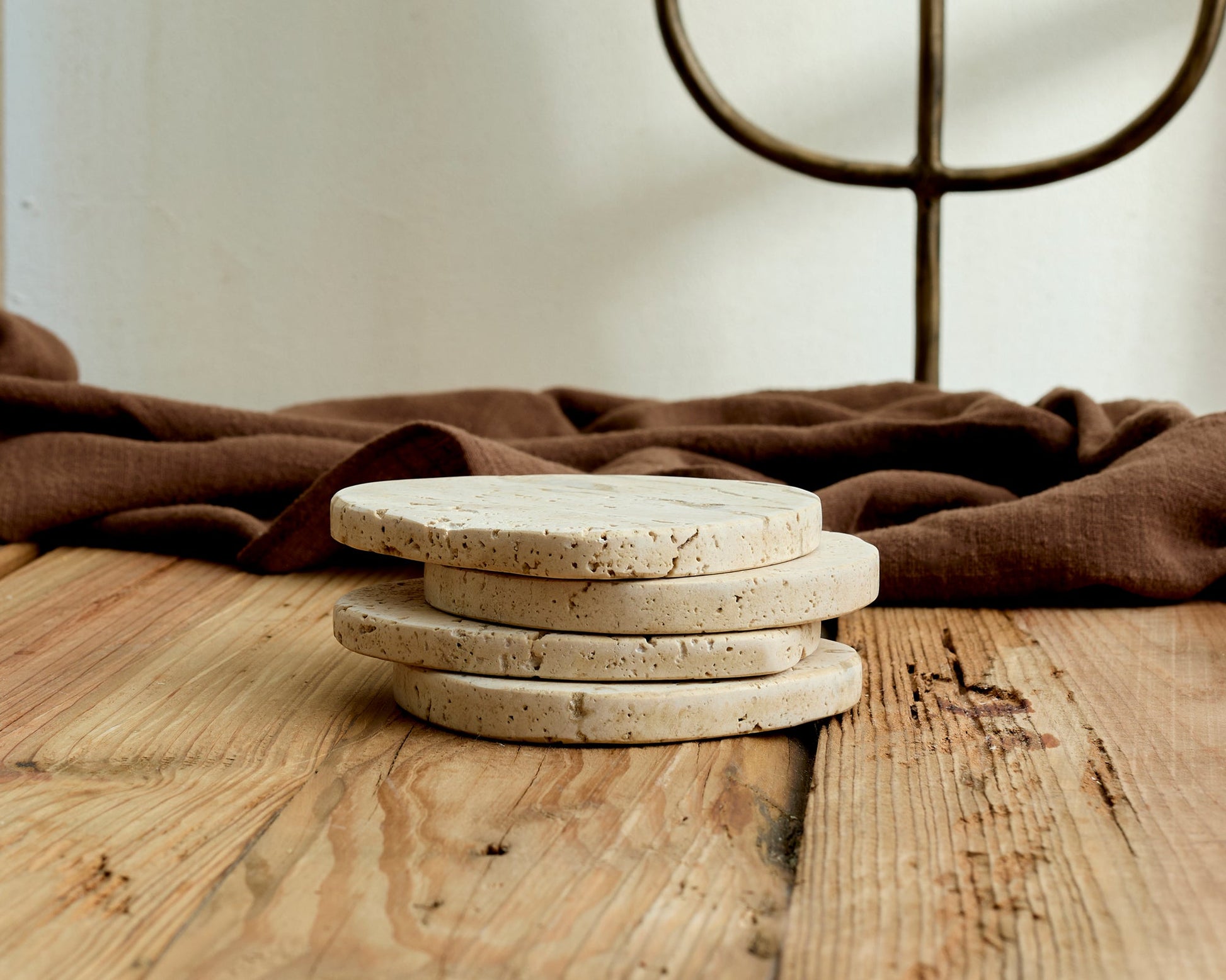 Artisan travertine coaster close-up showing unique organic shape natural stone veining texture