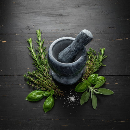 Black marble pestle and mortar on rustic black tabletop with scattered herbs, polished finish and countryside kitchen charm