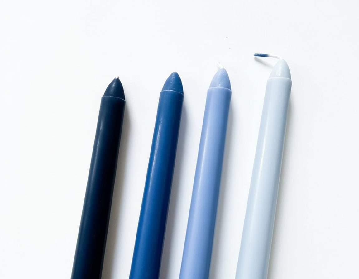Blue taper candles floral scented box of four displayed on blank background from another angle
