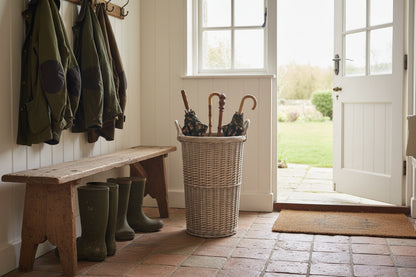 Handwoven willow umbrella stand in an antique wash finish, cylindrical shape with woven texture, suitable for umbrellas and walking sticks.