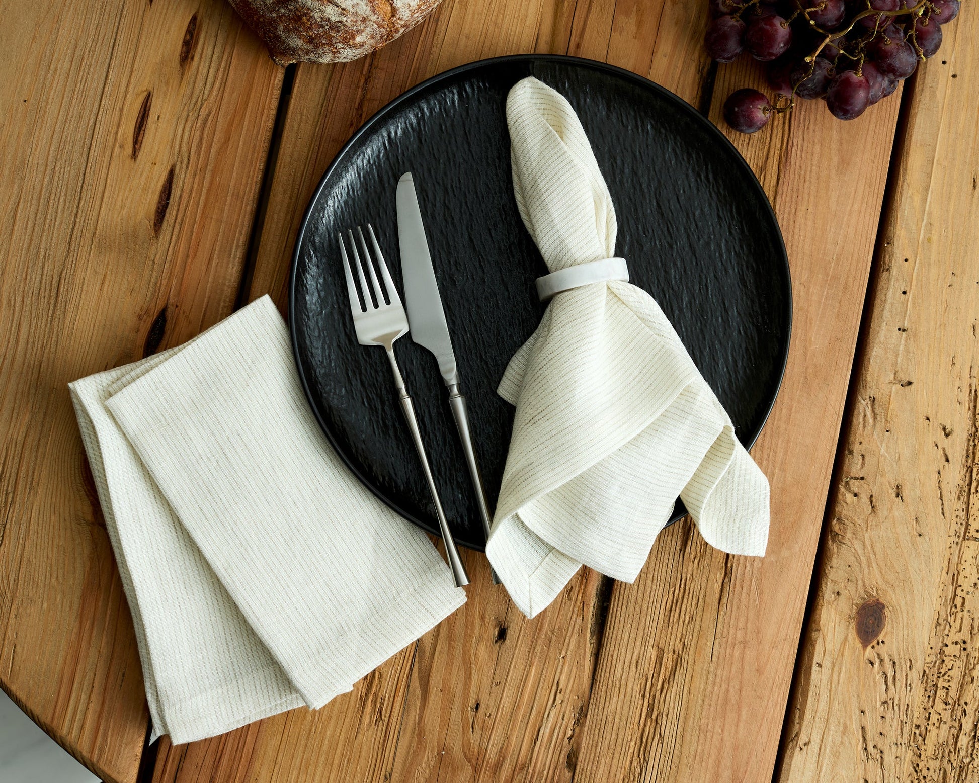 Chelsea Marble Napkin Rings polished natural stone set displayed on black plate with cutlery