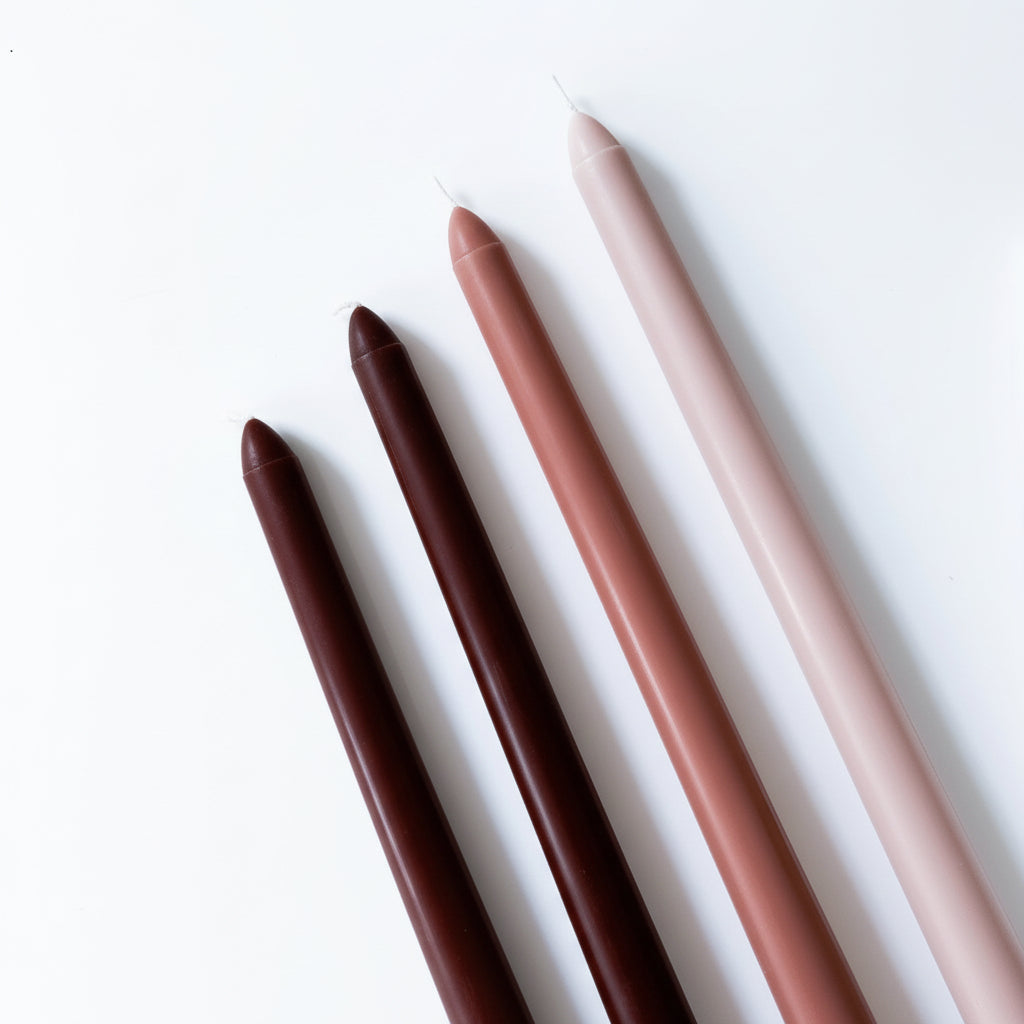 Creamy coffee scented tapers in candle holders fireside evening cottage living room ambience UK