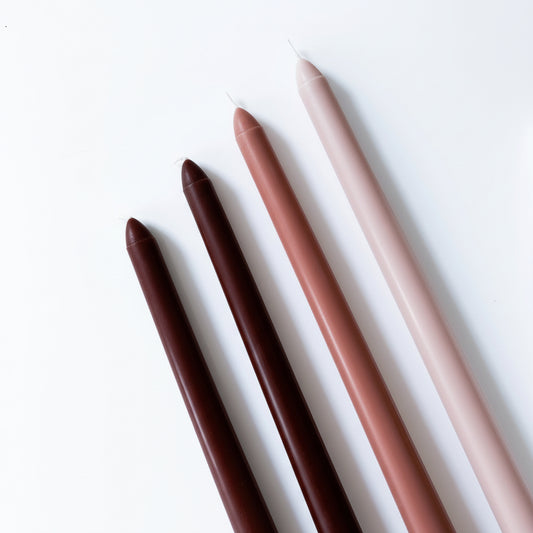 Creamy coffee scented tapers in candle holders fireside evening cottage living room ambience UK