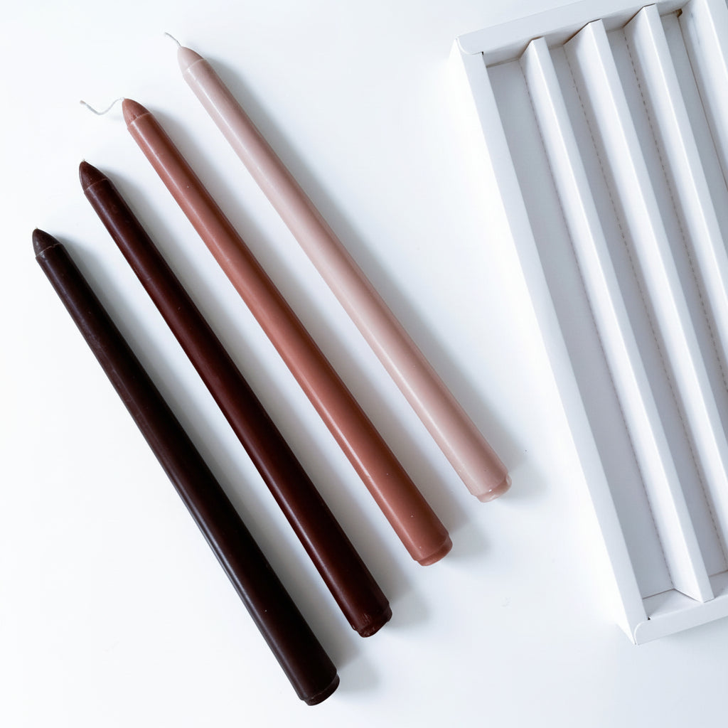 Coffee taper candles burning on farmhouse dining table warm ambient candlelight cottage interiors UK