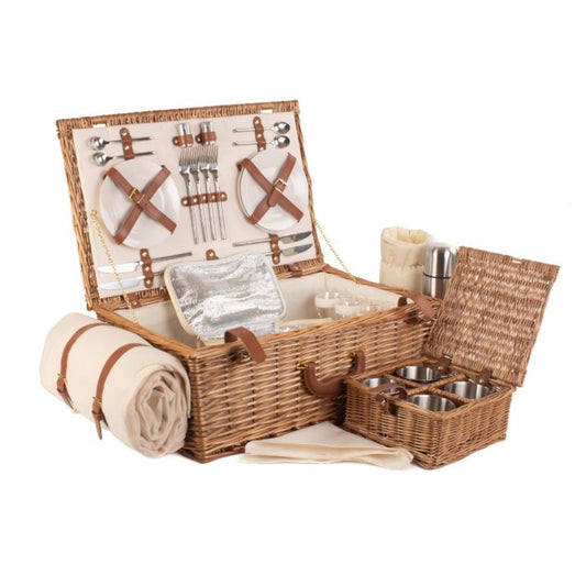 Top view looking inside deluxe wicker picnic basket for four, open with fitted accessories on plain background