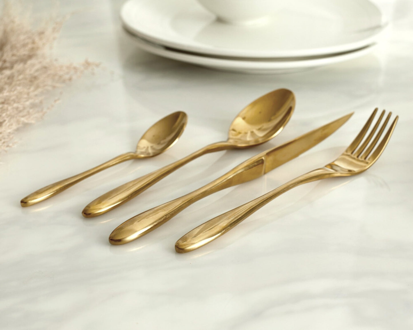 Gold stainless steel cutlery set 16 piece flatware on marble table UK