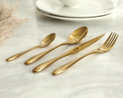 Gold stainless steel cutlery set 16 piece flatware on marble table UK