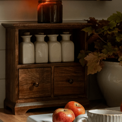 Mabel wooden cabinet 2 drawer mango wood kitchen storage styled on worktop with storage jars on top

