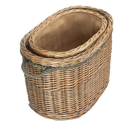 Side view oval wicker log baskets stacked nested set rope handles plain background UK