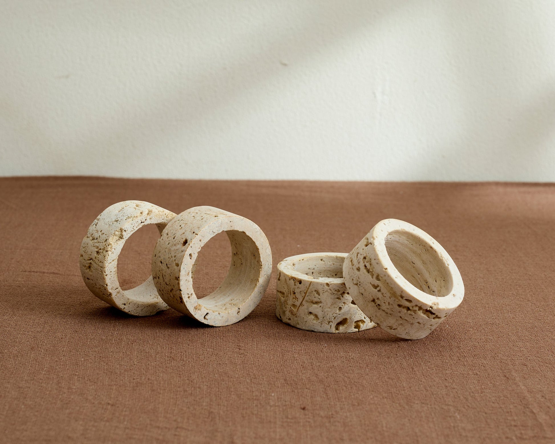 Langley travertine napkin rings set of 4 artisan stone table accents displayed on table top
