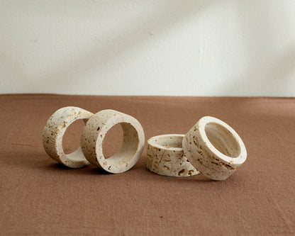 Langley travertine napkin rings set of 4 artisan stone table accents displayed on table top
