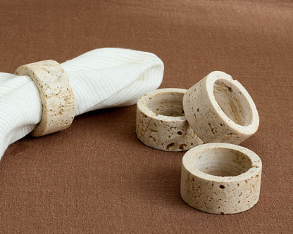 Langley travertine napkin rings set of 4 artisan stone table accents displayed on table top
