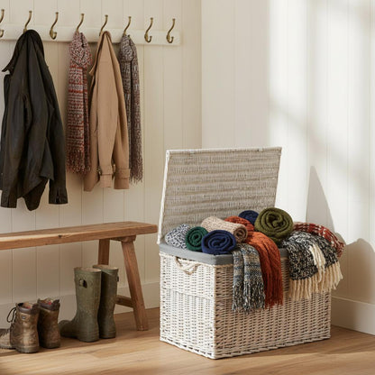 Large whitewash wicker basket in country hallway with throws - practical UK storage