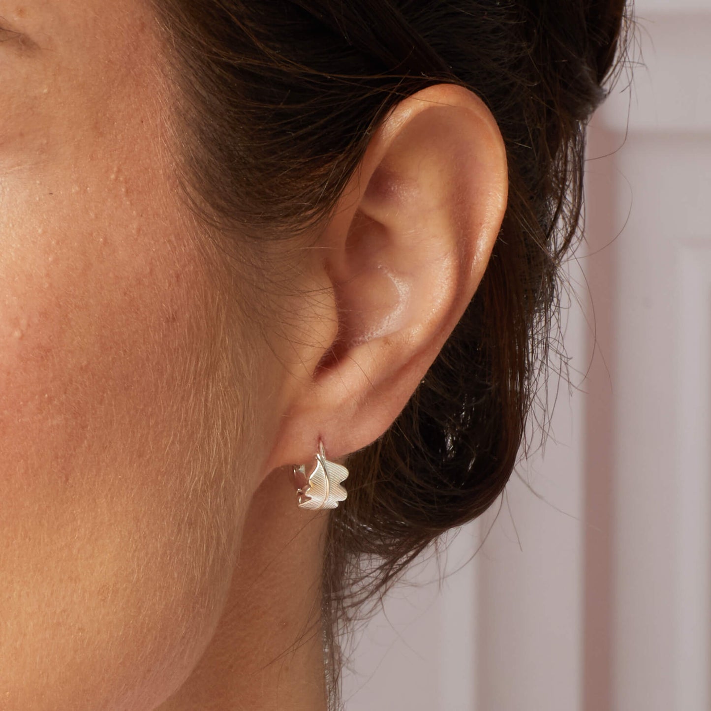 Close up Laura Ashley Broadoak mini hoop earring on model sterling silver UK
