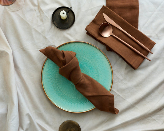 Muslin cotton napkins set of 4 Branwell Brown Rustic styled on jade plate with copper cutlery and black iron candle holder
