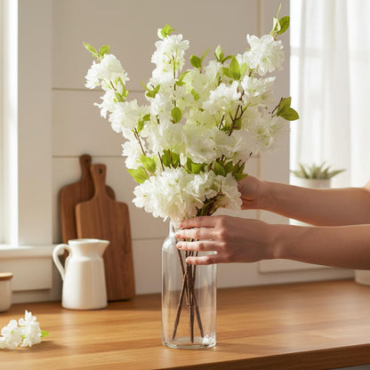 Realistic faux white blossom stems being arranged showing quality UK
