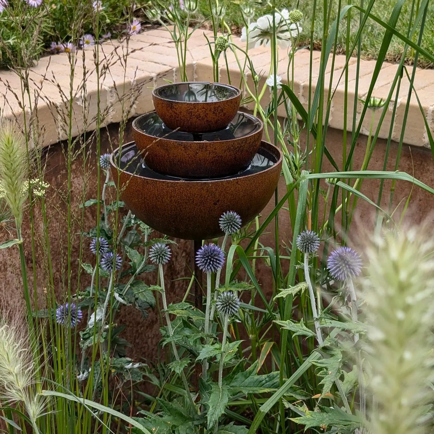 Rusted garden fountain stake rain catcher three-tier bowls purple thistle cottage garden UK