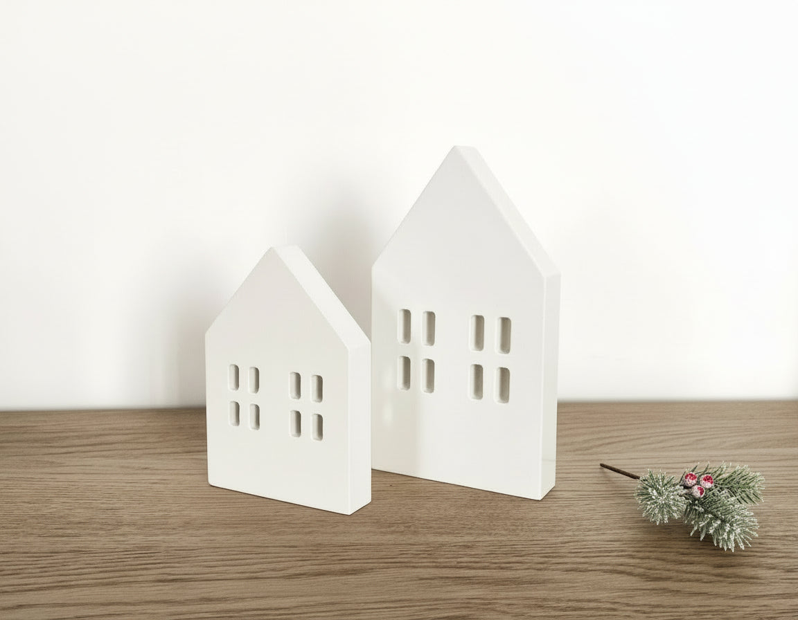 Scandi wooden Christmas village houses Nordic decoration on wooden mantle with festive sprigs
