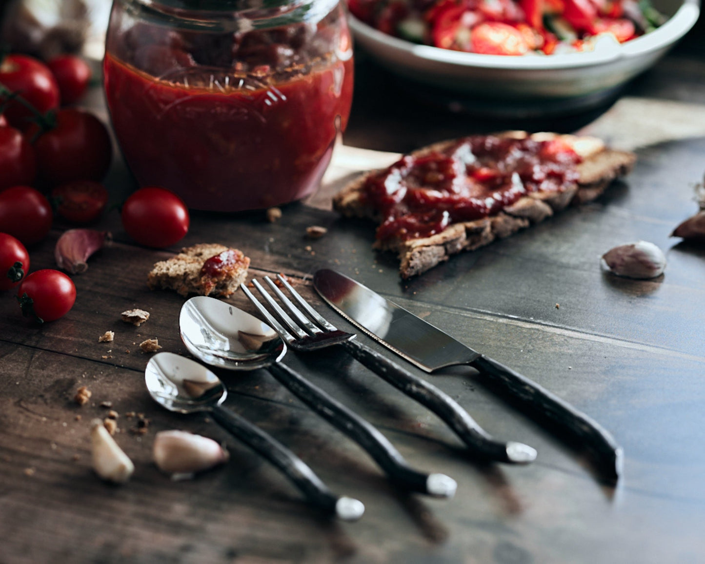 Silver cutlery set stainless steel Elmswell Rustic close up styled with tomatoes and sauce
