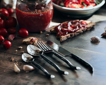 Silver cutlery set stainless steel Elmswell Rustic close up styled with tomatoes and sauce
