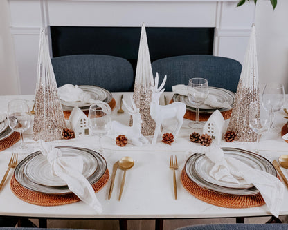 Set of three snowed Christmas cone trees festive mantel decorations on tablescape with seasonal styling
