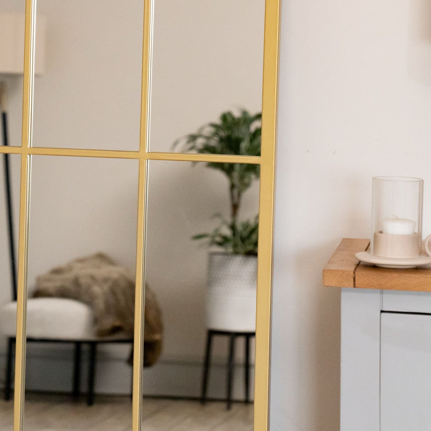 Close-up of gold arched mirror frame with lattice detailing — antique-style metal finish inspired by countryside architecture