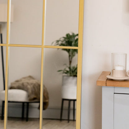 Close-up of gold arched mirror frame with lattice detailing — antique-style metal finish inspired by countryside architecture