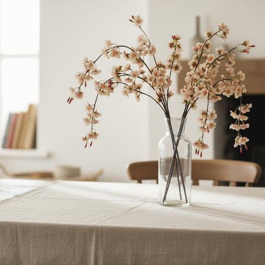 Trailing cherry blossom stems in tall vase rustic farmhouse table styling UK