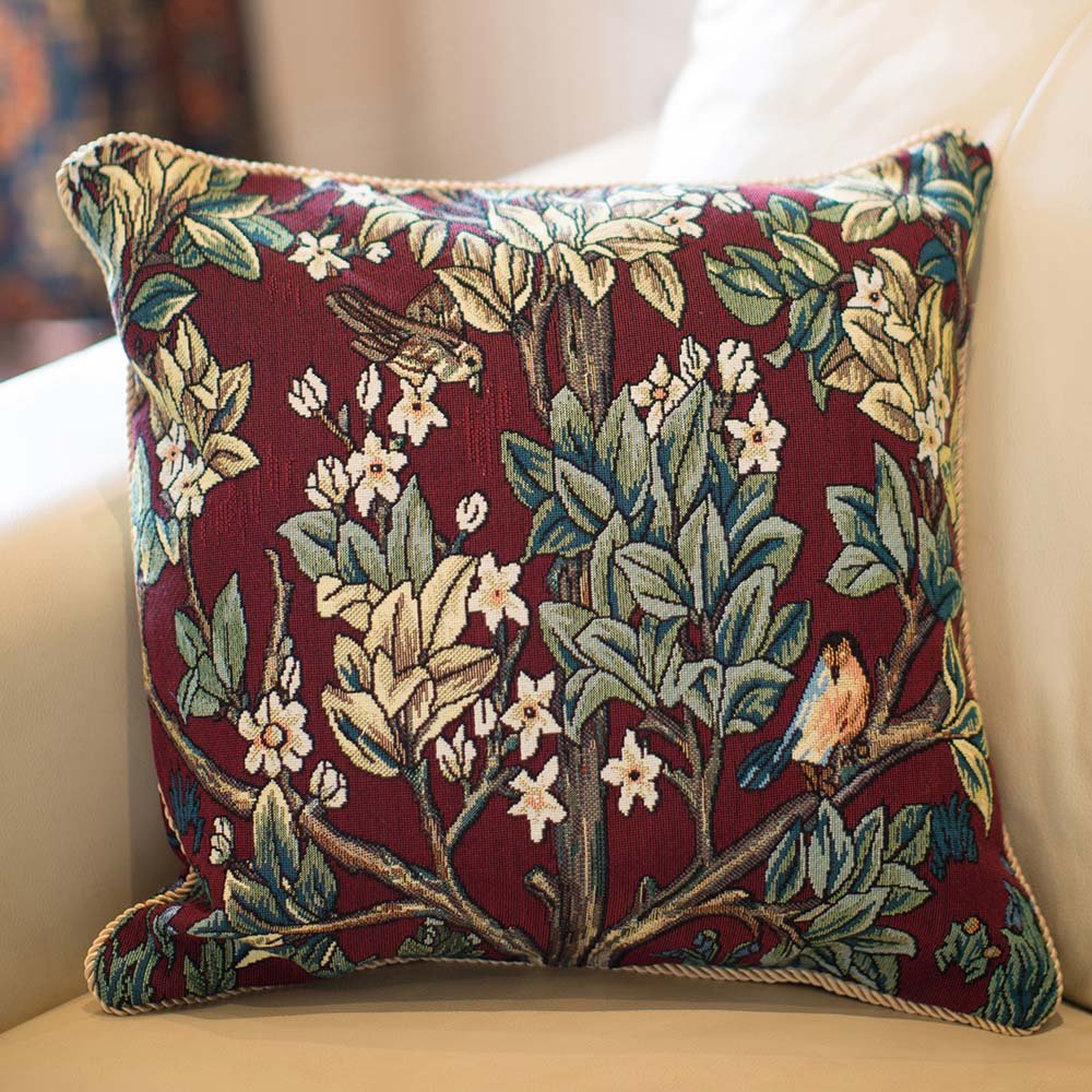 Tree of Life cushion in rich red tapestry, William Morris design, nestled into armchair for cosy countryside styling and soulful comfort