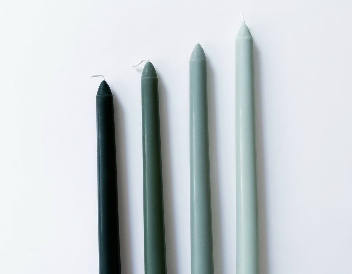 Woodland taper candles box of 4 rustic scented green laid on white surface showing colour and shape
