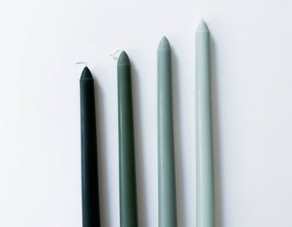 Woodland taper candles box of 4 rustic scented green laid on white surface showing colour and shape
